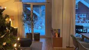 A modern living room with a large window, a fireplace, and a Christmas tree. - Lovingly furnished vacation home in the immediate vicinity of the lake (Mirow OT Granzow)