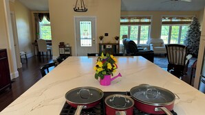 A kitchen with a large island, a dining area, and a living room. - Couples Villa Retreat w/85” Sony HD 8K TV Pool table New Jacuzzi Spa & Game room (Conway)