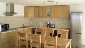 A modern kitchen with wooden cabinets, a stainless steel refrigerator, a microwave, and a coffee maker. - Magnificent Gite with dominant view swimming pool and jacuzzi (L'Olivier) (Langlade)
