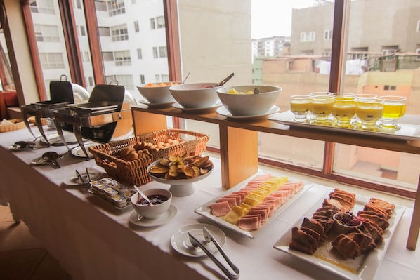 A buffet table with various food items and drinks. - EPIQUS HOTEL (Lima)