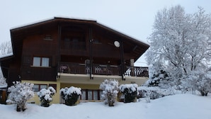 A two-story wooden building with balconies and a snow-covered landscape. - LA COURTIONE APARTMENT IN CHALET (Samoëns)