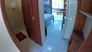 Una habitación con una cama, televisión y vistas al exterior.