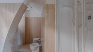 Ein modernes Badezimmer mit Dusche, Toilette und Bidet.
