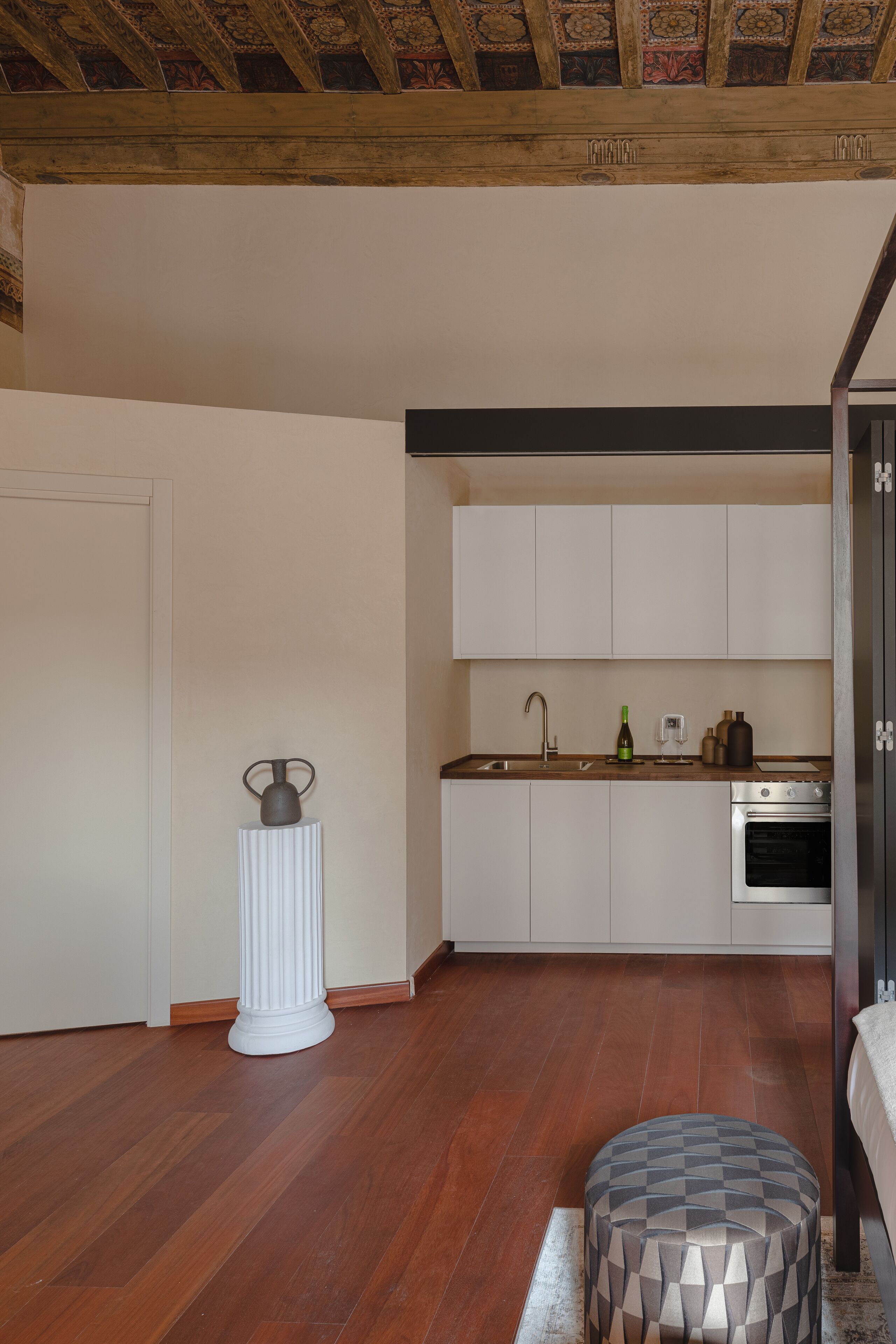 A modern kitchen with white cabinets, a wooden countertop, and a built-in oven.
