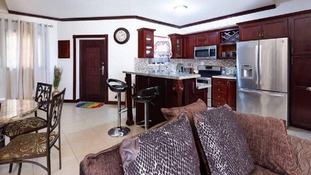 A compact living space with a kitchenette, a dining area, and a sofa.