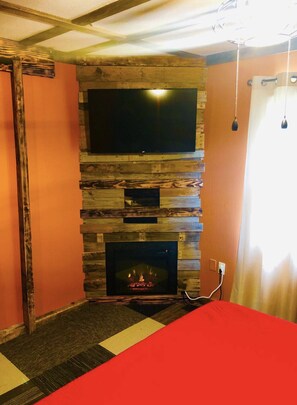 Cozy retreat with a fireplace, flat-screen TV, and comfortable bed.
