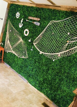 Relax in a cozy space with hammocks suspended from the ceiling and nautical-themed decor.