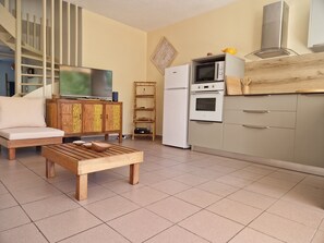 Een moderne woonkamer met een bank, salontafel en televisie.