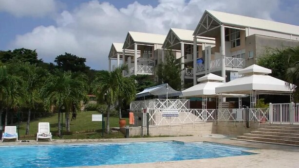 A hotel with a swimming pool, multiple balconies, and a tropical garden. - Nice Duplex 6 persons in secured residence with swimming pool (Le Diamant)