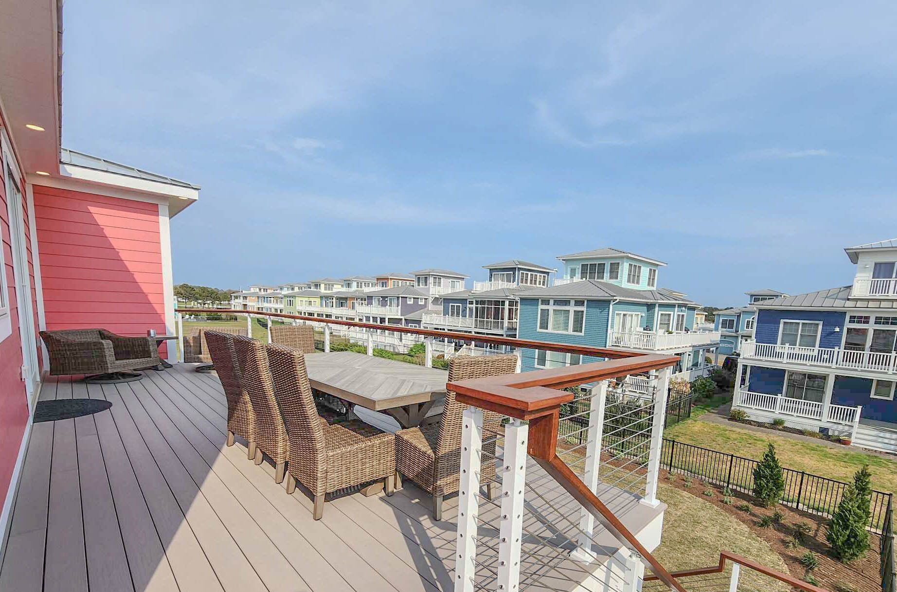 A deck with wicker furniture and a view of colorful houses.