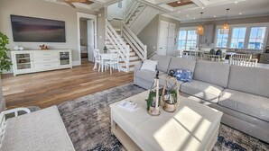 A spacious living area with a staircase, a dining area, and a kitchen. - Gorgeous water views, a private swimming pool & easy access to private beach! (Cape Charles)