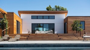 A modern house with a swimming pool, wooden exterior, and a seating area with a sofa and chairs. - Year-Round Heated Pool | Hot Tub | Fire Pit | Huge Lawn | Vineyard Views (Kenwood)