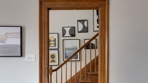 Eine Holztreppe führt zu einer Empore mit einer weißen Wand.