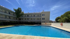 Ein Schwimmbad mit klarem, blauem Wasser, umgeben von einer gepflasterten Terrasse.