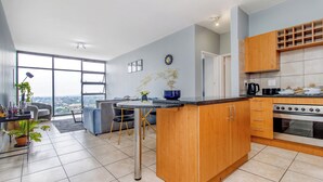 Een moderne keuken met houten kastjes, een inbouwoven en een eetgedeelte met uitzicht.