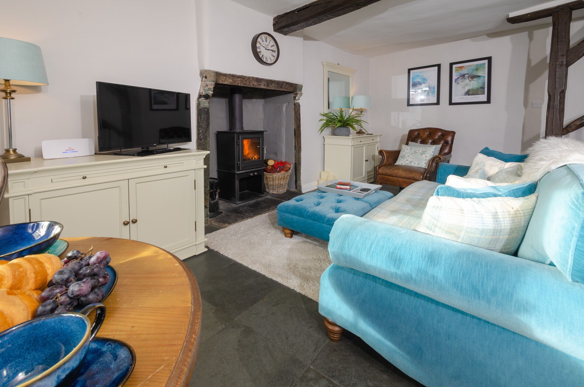 A cozy living room with a fireplace, a television, and a comfortable sofa.