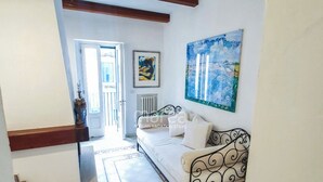 A bedroom with a bed, a radiator, and a painting on the wall. - Historic home with a sea-view terrace in the heart of Otranto - Marea Stays Collection (Otranto)
