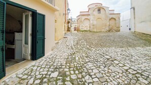 A cobblestone street leading to a historic stone building with a bell tower. - Historic home with a sea-view terrace in the heart of Otranto - Marea Stays Collection (Otranto)
