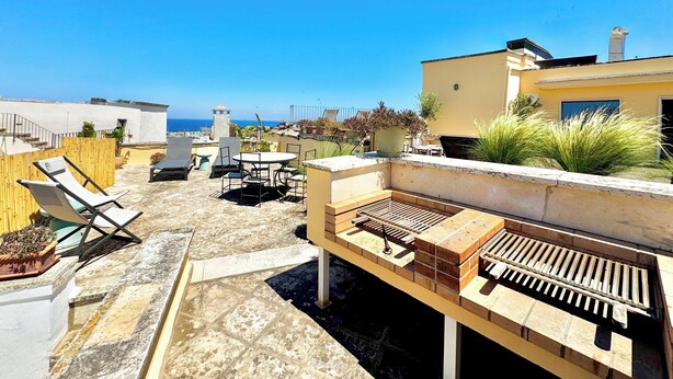 A rooftop terrace with outdoor seating, a grill, and potted plants. - Historic home with a sea-view terrace in the heart of Otranto - Marea Stays Collection (Otranto)