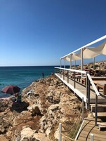 Um terraço à beira-mar com área de estar ao ar livre e vista para o mar.
