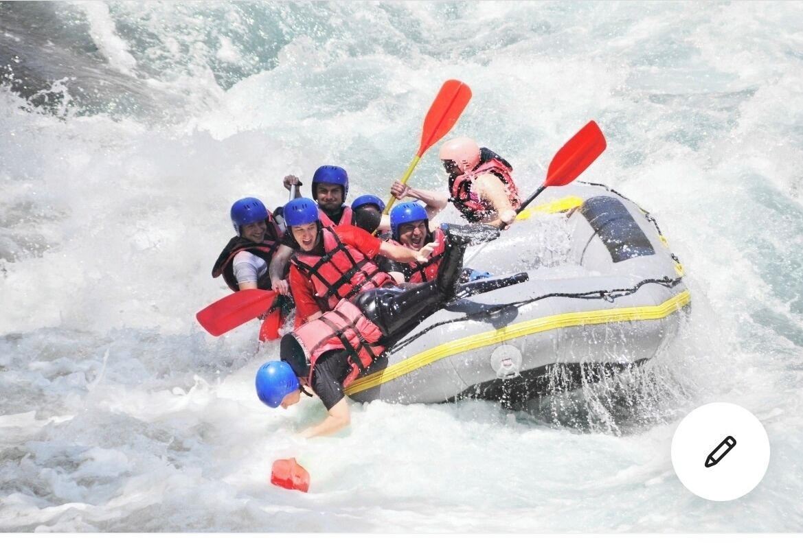 Un groupe de personnes à bord d’un radeau naviguant sur des eaux agitées.