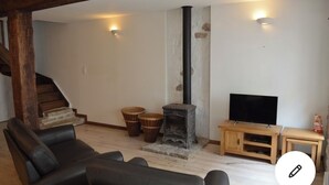 A living room with a fireplace, a television, and a staircase. - Lovely renovated Cottage in Puivert (Puivert)