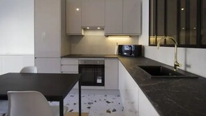 Een moderne keuken met een zwart aanrecht, een inbouwoven en een magnetron.