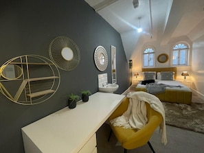 A bedroom with a bed, bedside tables, a desk, and a chair. - Molly Central House (Brighton)
