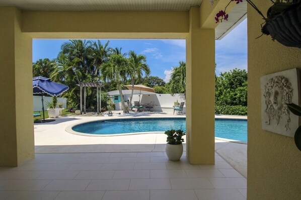 Relax by the pool surrounded by lounge chairs, umbrellas, and a shaded gazebo.