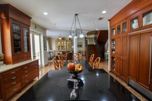 Enjoy cooking in this well-equipped kitchen with a central island, sink, and glass-fronted cabinetry.