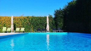 A clear blue pool with lounge chairs and umbrellas, surrounded by a hedge. - BEAUTIFUL APARTMENT X 5 WITH HOT-HUB POOL ABOUT 2 KM FROM THE SEA (Imperia)