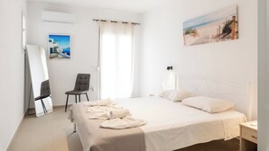 Ein Hotelzimmer mit einem Bett, einem Sessel, einem Schreibtisch, einem Spiegel und einem Bild an der Wand.