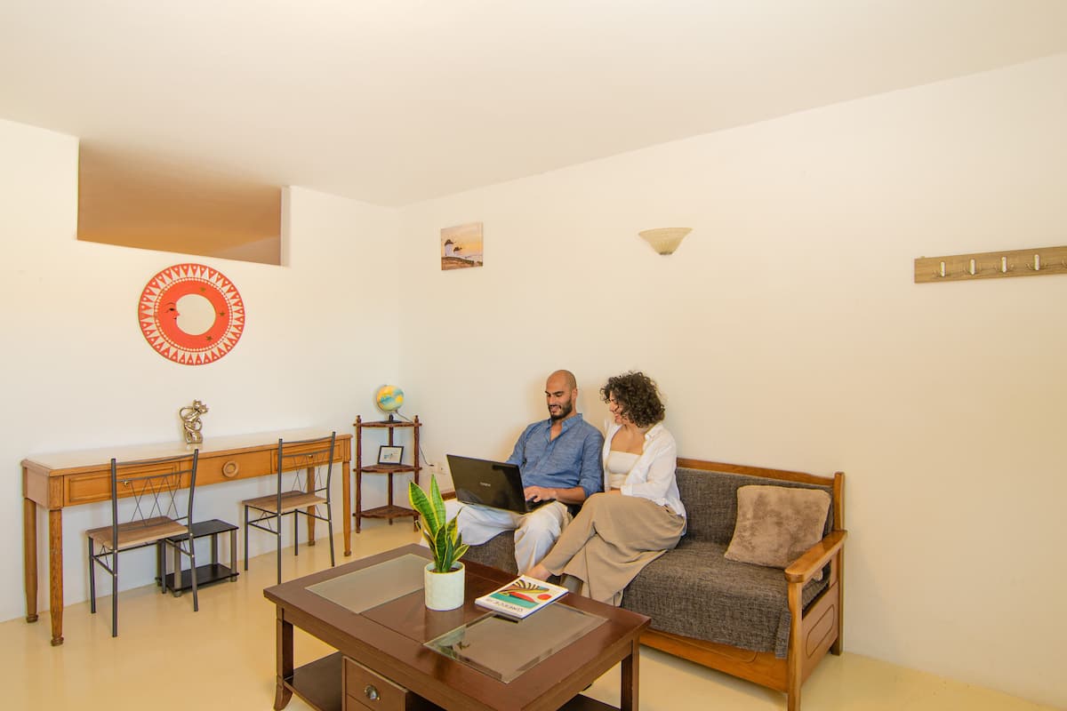 Ein Wohnzimmer mit einer Couch, einem Couchtisch und einem Schreibtisch mit Stühlen.