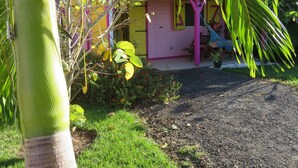 Una casa con fachada rosa y un pequeño porche.