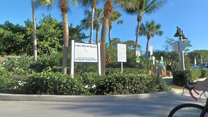 Een bord voor Lake Worth Beach, een parkeersbord en een fiets op de voorgrond.