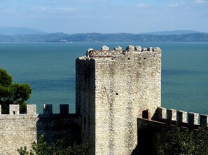 A stone tower with battlements overlooking a body of water.