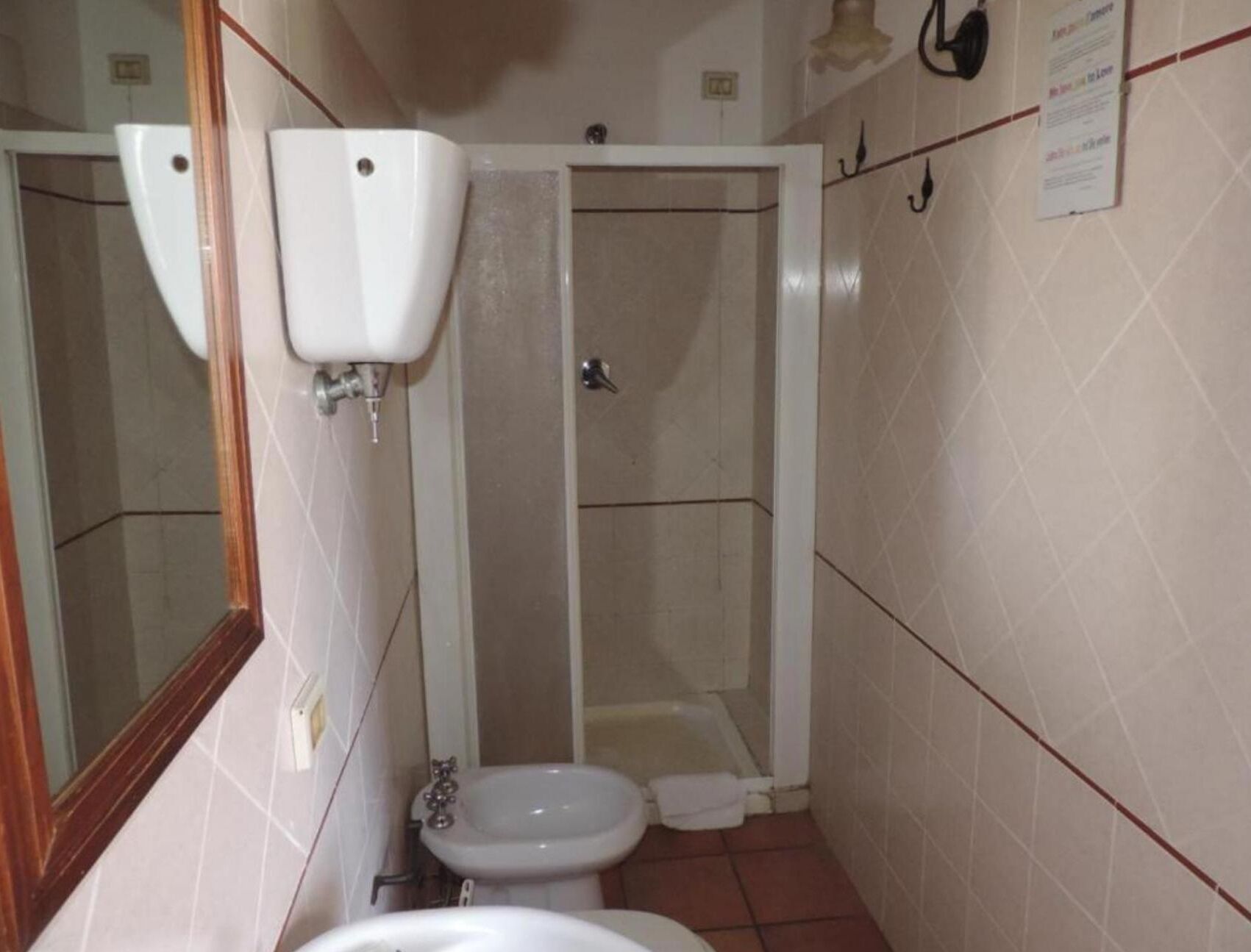 A small bathroom with a toilet, bidet, and a shower stall.
