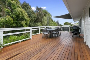 Enjoy al fresco dining and socializing on this spacious deck surrounded by lush greenery.