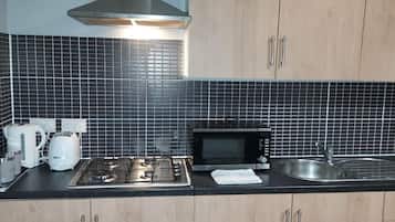 Apartment, Multiple Beds | Private kitchen | Fridge, microwave, stovetop, electric kettle