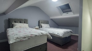 A bedroom with two beds, a skylight, and a small window. - 2 Bedrooms Apartment in Main Street Mexborough (Mexborough)