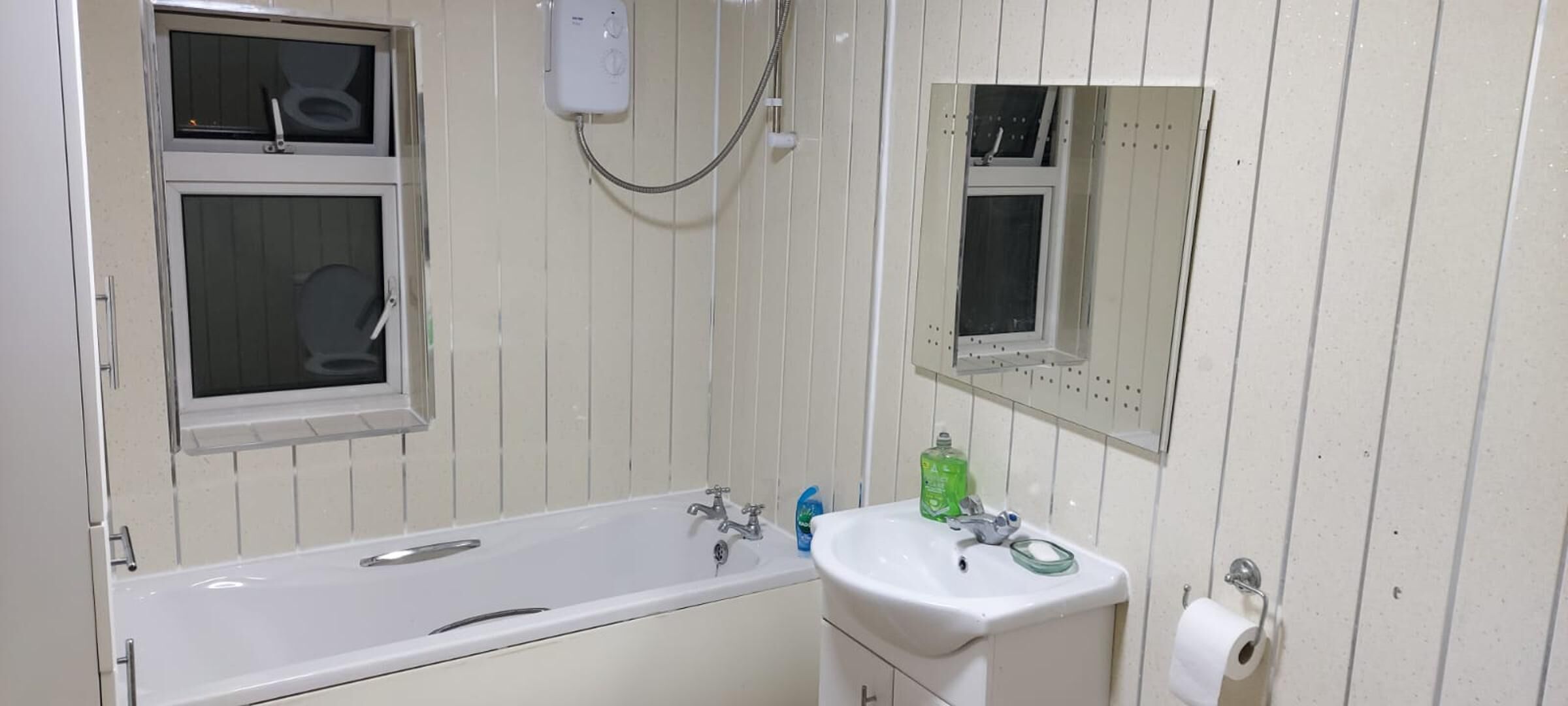 A bathroom with a bathtub, a sink, a mirror, and a toilet.