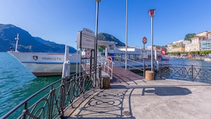 A pier with a boat named 'Morcote' docked, a sign indicating 'Partenze', and a 'No Entry' sign. - Icon H 405 Suite Business (Lugano)