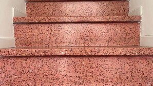 Portaat, joiden askelmat on päällystetty terrazzolla, johtavat ylätasanteelle.