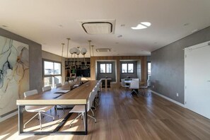 A spacious conference room with a long table, white chairs, and pendant lighting. - Studio/apartment (São Paulo)