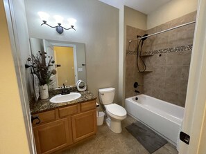 Bathtub, hair dryer, towels, toilet paper