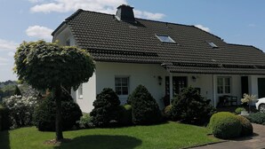 A two-story house with a tiled roof, a chimney, and a small window. - Funke Vacation Rental (Reichshof)