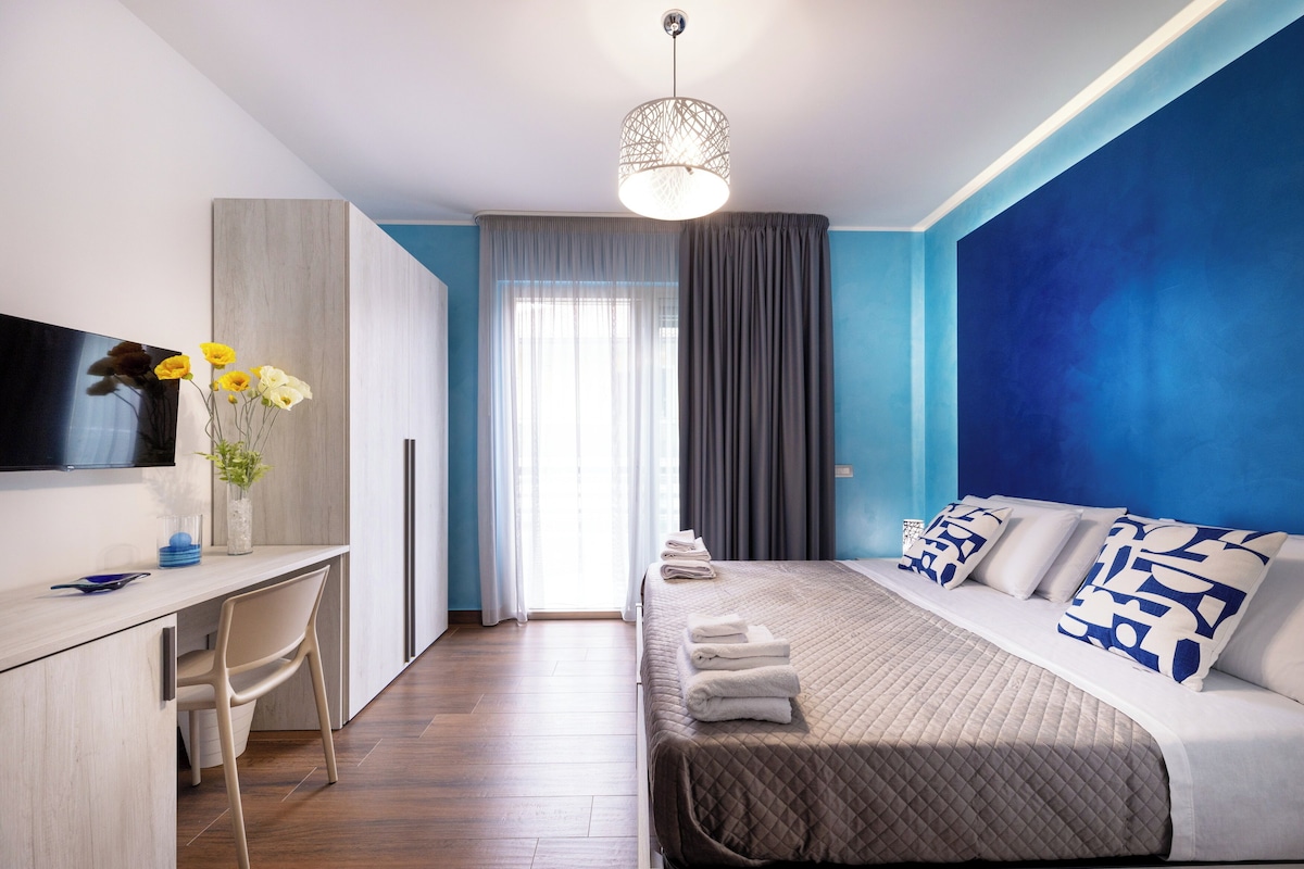 Une chambre d’hôtel moderne équipée d’un lit, d’un bureau et d’une télévision.