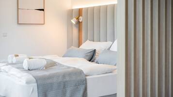 Ein Hotelzimmer mit einem großen Bett, einem Nachttisch, einer Lampe und einem an der Wand befestigten Kunstwerk.