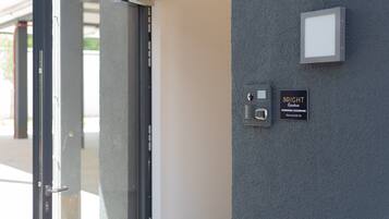 A door with a glass panel and a wall-mounted intercom system.