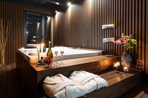 Un baño moderno con un tocador de madera, una bañera grande y una zona de estar con toallas.